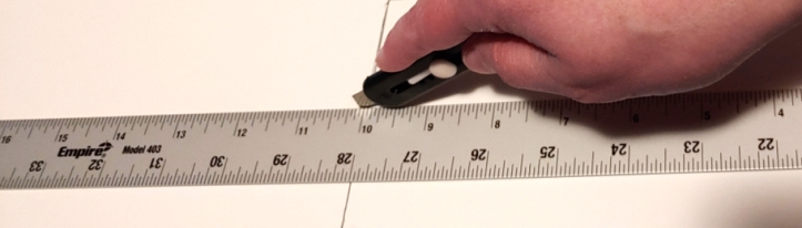 Cutting next to a metal ruler with a small box knife