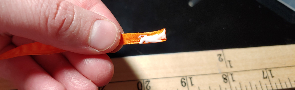 Tacky glue on the edge of a paper strand