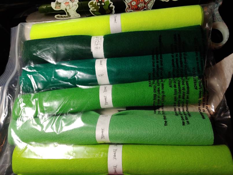 Sampler pack of green acrylic felt. Several rolls of green in various shades stacked up